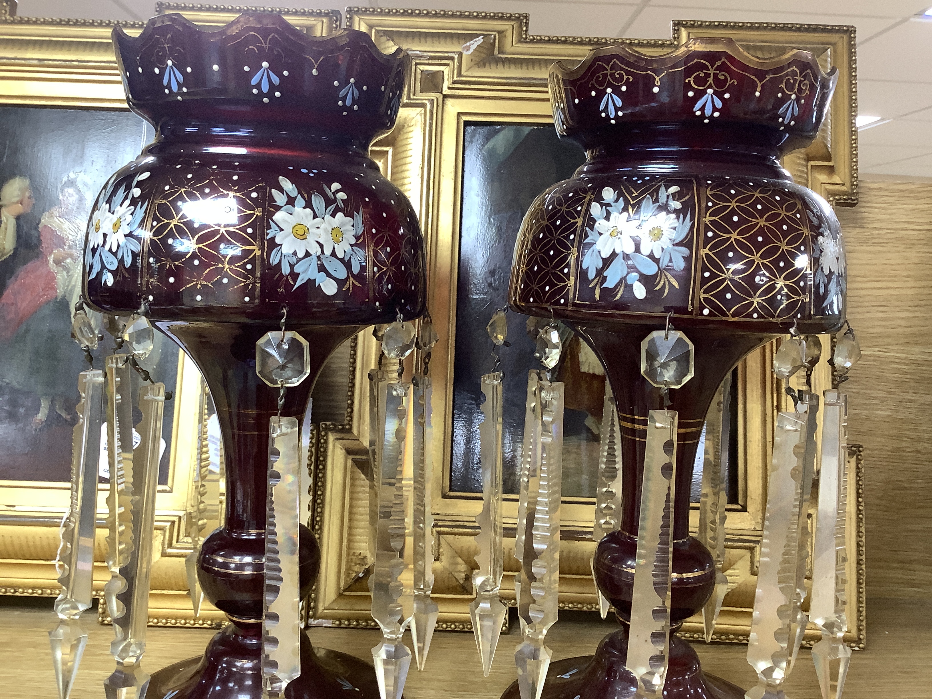 A pair of late 19th century ruby glass floral enamelled table lustres, 35.5cm high